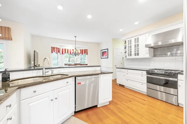 a kitchen with stainless steel appliances granite countertop a sink and cabinets