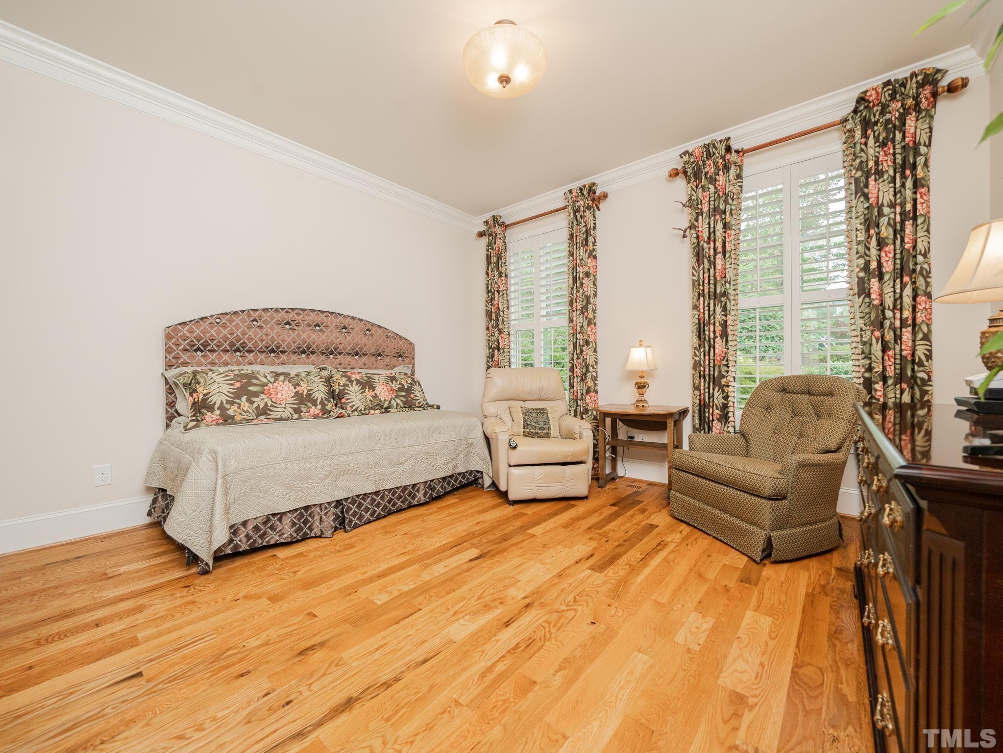 842 Cranbrook Road Raleigh, NC 27609 - Photo 28 of 39 a spacious bedroom with a bed and a couch