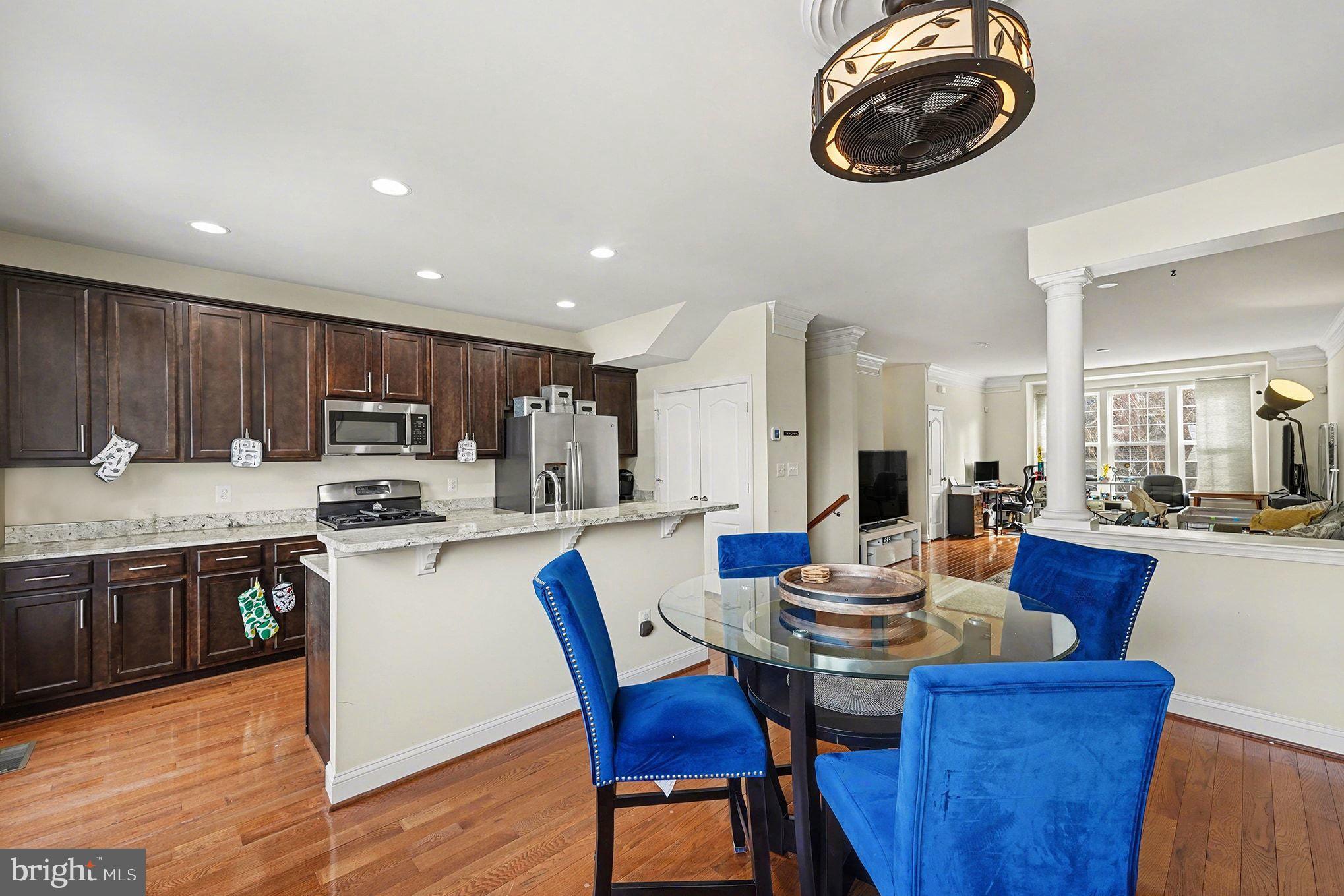4440 Potomac Highlands Circle Triangle, VA 22172 - Photo 13 of 34 a kitchen with a dining table chairs and stove