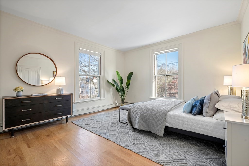 105 Eldredge Street Newton, MA 02458 - Photo 22 of 42 a bedroom with a bed a potted plant and a dresser