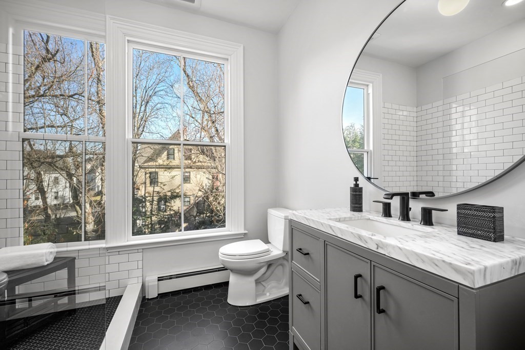105 Eldredge Street Newton, MA 02458 - Photo 24 of 42 a bathroom with a granite countertop sink mirror vanity and toilet