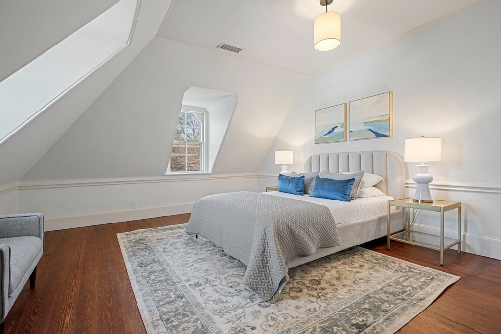 105 Eldredge Street Newton, MA 02458 - Photo 34 of 42 a bedroom with a bed lamps and wooden floor