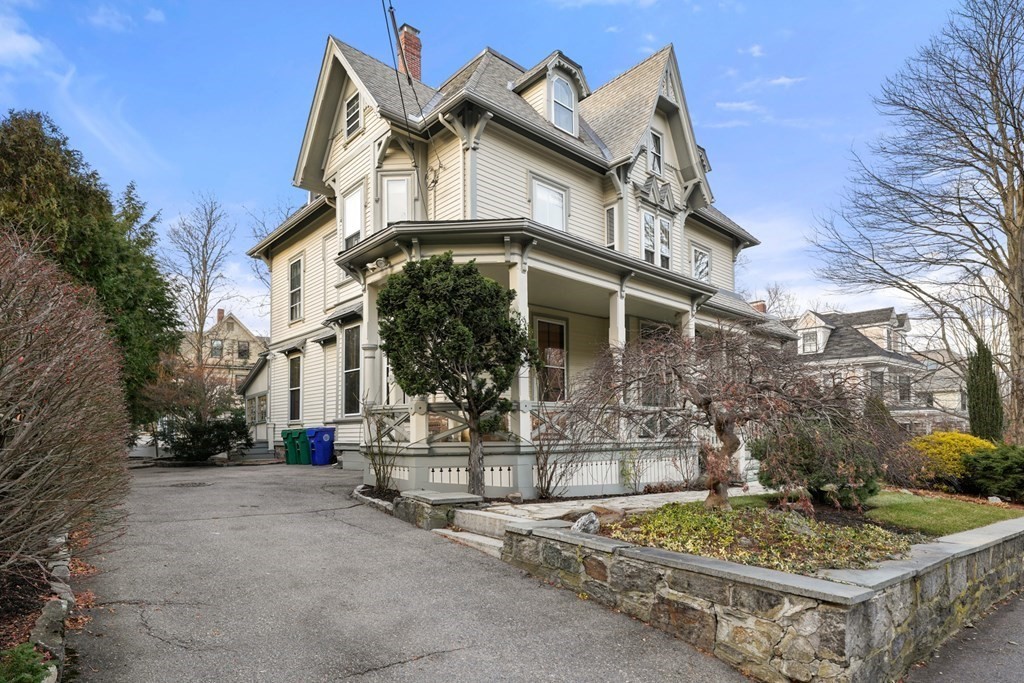 105 Eldredge Street Newton, MA 02458 - Photo 39 of 42 a view of a white house with large windows and a table and chairs