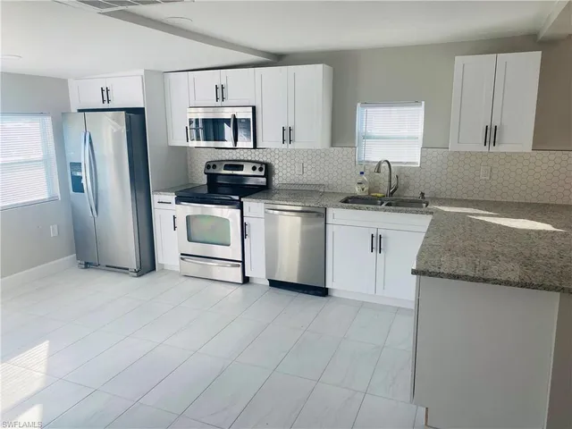 a kitchen with stainless steel appliances granite countertop a stove a sink and a refrigerator