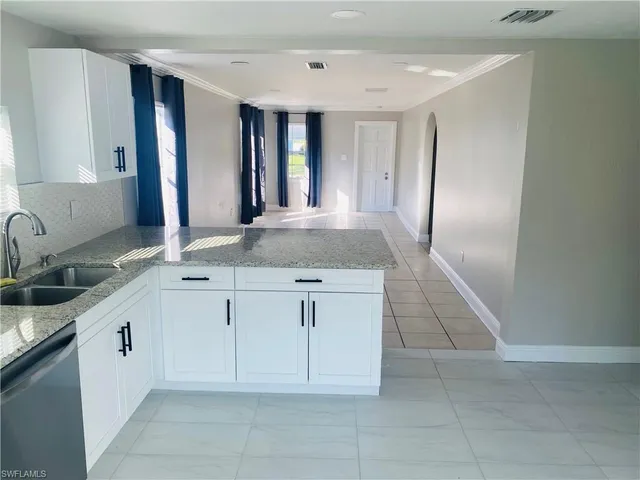 a spacious bathroom with a granite countertop sink and a mirror