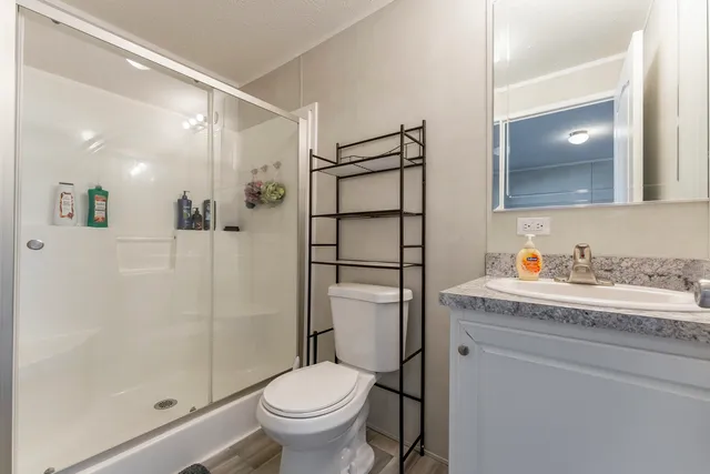 a bathroom with a granite countertop sink toilet and shower