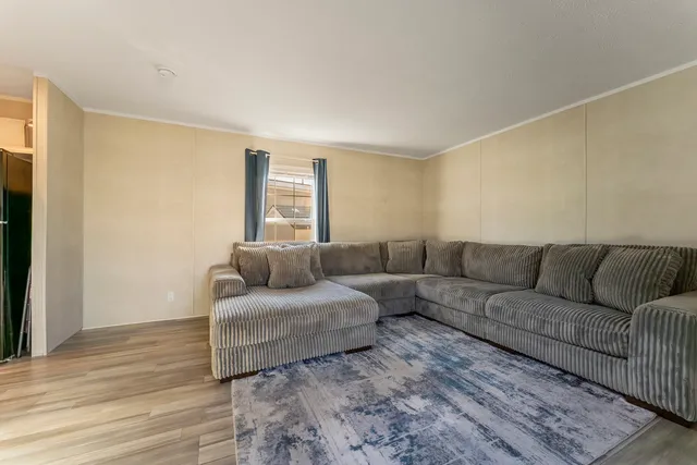 a living room with a couch and a dresser with wooden floor