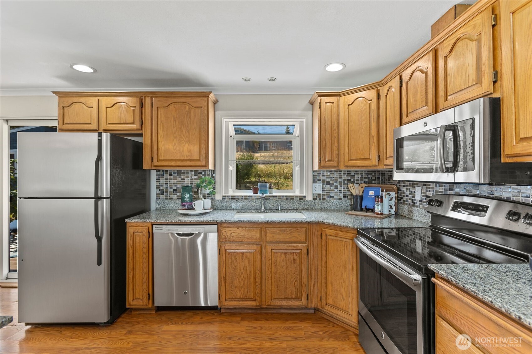 216 Bridgeway Everett, WA 98201 - Photo 19 of 40 a kitchen with granite countertop a refrigerator stove top oven and sink