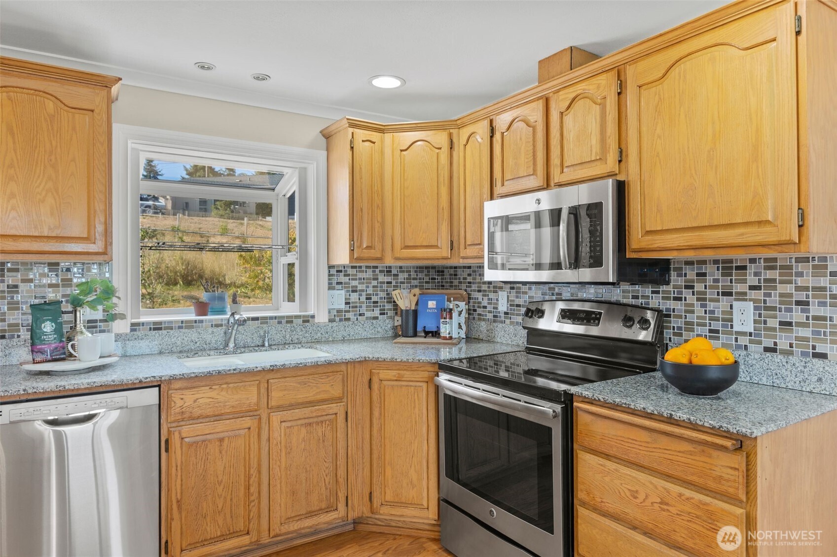 216 Bridgeway Everett, WA 98201 - Photo 20 of 40 a kitchen with stainless steel appliances granite countertop a stove a sink dishwasher and cabinets with wooden floor