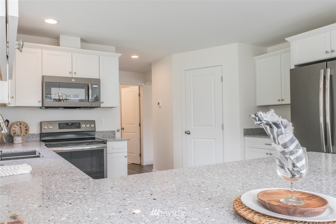 17916 Tester Road Snohomish, WA 98290 - Photo 8 of 28 a kitchen with stainless steel appliances granite countertop a sink a stove a refrigerator and cabinets