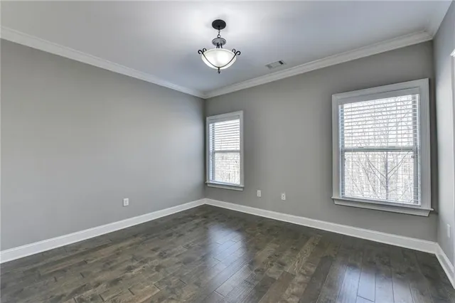 a view of an empty room with wooden floor