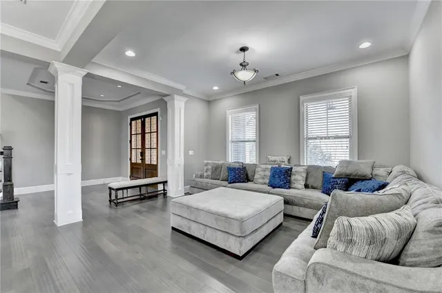 a view of a dining room and livingroom with furniture wooden floor a chandelier