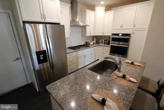a kitchen with refrigerator and white cabinets