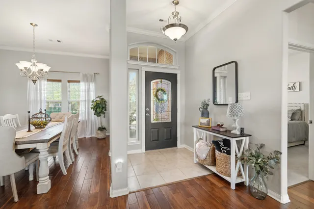 a view of a hallway with dining room and wooden floor