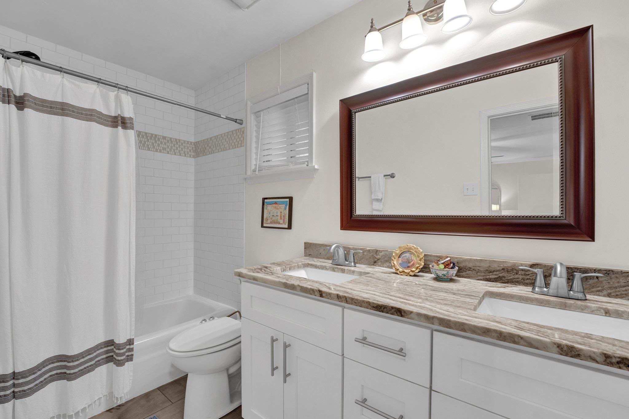 1459 Colonial Road Memphis, TN 38117 - Photo 21 of 33 a bathroom with a granite countertop sink vanity mirror and toilet