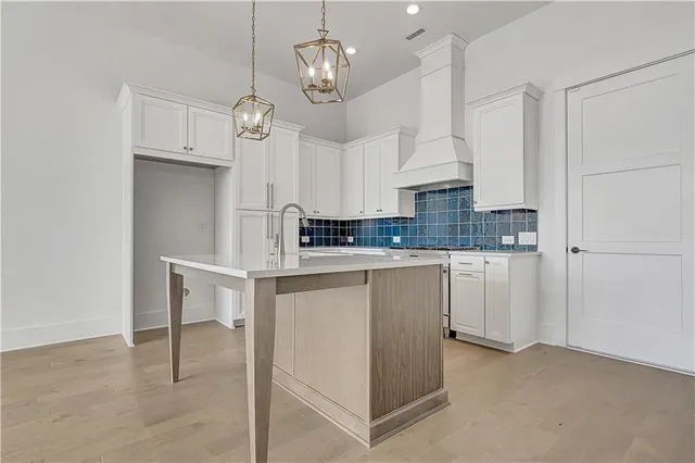 a kitchen with stainless steel appliances granite countertop a sink a stove and refrigerator