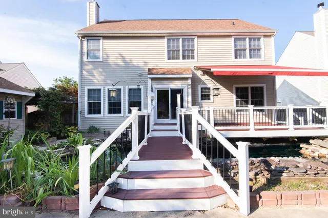 a front view of a house with wooden stairs and a table