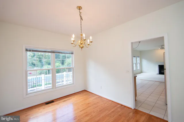 a view of a livingroom with a chandelier wooden floor and a chandelier