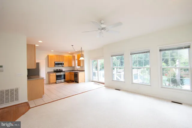 a living room with furniture a table and chairs with kitchen view
