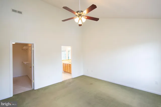 a view of a livingroom with a ceiling fan & window