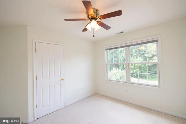 an empty room with a window and a fan