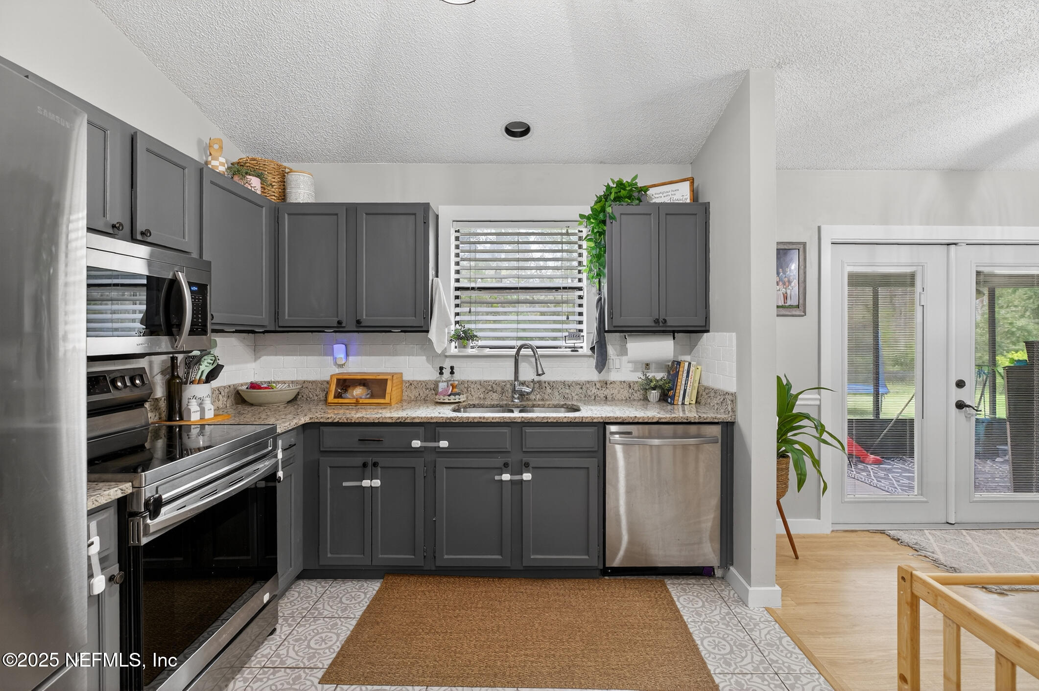 2172 Rothbury Drive Jacksonville, FL 32221 - Photo 13 of 28 a kitchen with stainless steel appliances granite countertop a sink stove and refrigerator