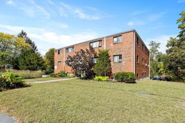 a front view of a house with a yard and trees