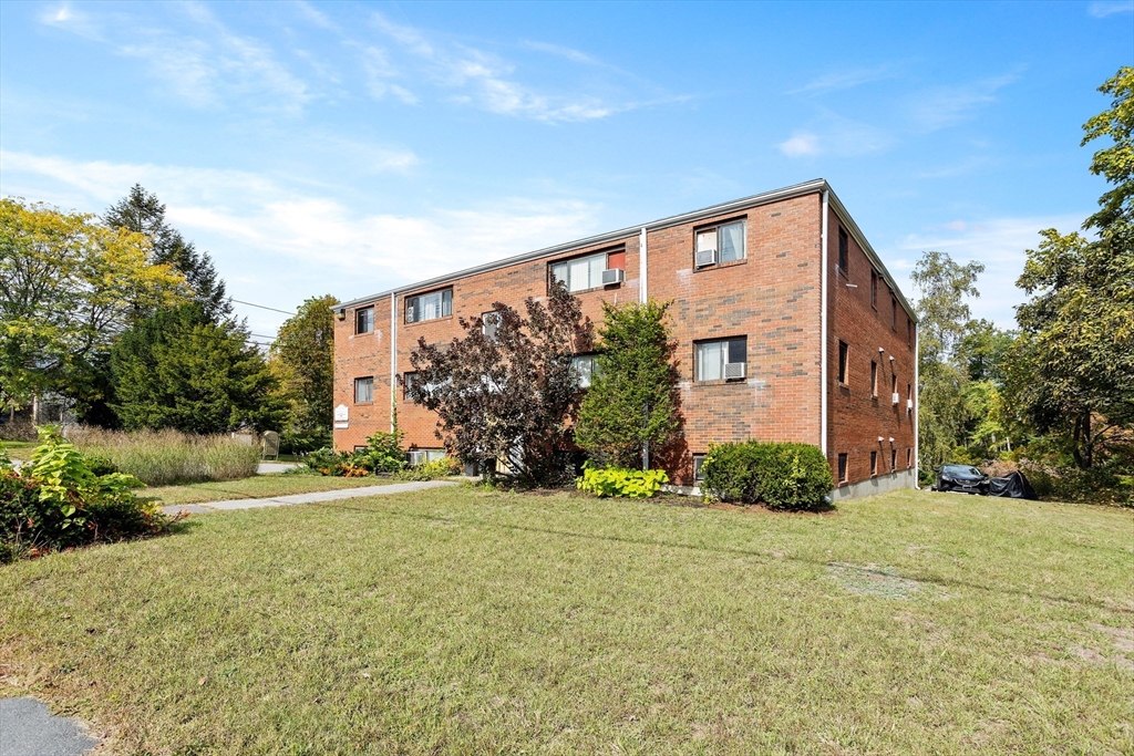a front view of a house with a yard and trees