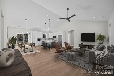 a living room with furniture kitchen view and a flat screen tv