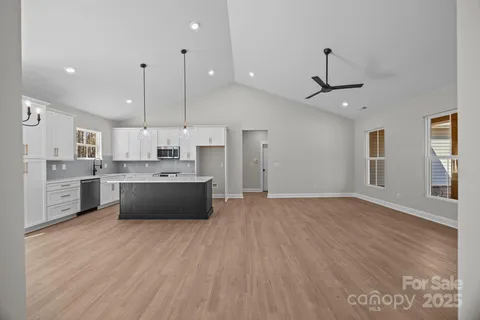 a large kitchen with stainless steel appliances kitchen island a sink and a large window