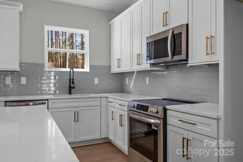 a kitchen with white cabinets stainless steel appliances and sink