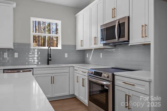 a kitchen with white cabinets stainless steel appliances and sink