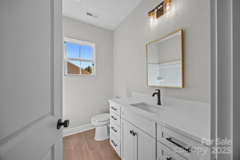 a bathroom with a double vanity sink toilet and mirror