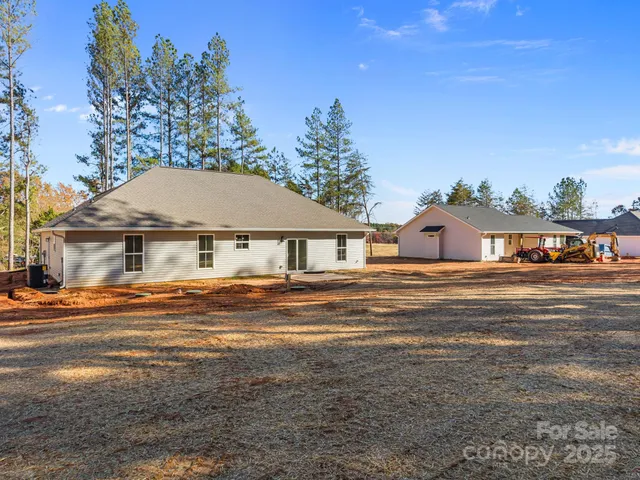 a view of a house next to a big yard with large trees