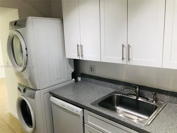 a kitchen with a sink and a washer dryer