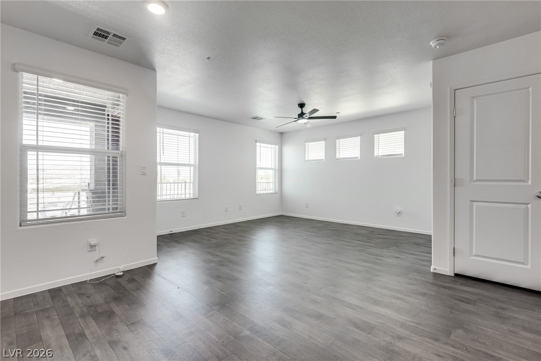 1114 Scarlet Sparrow Street Henderson, NV 89011 - Photo 8 of 25 A spacious room offers ample natural light and smooth wood-like flooring, ideal for versatile living.