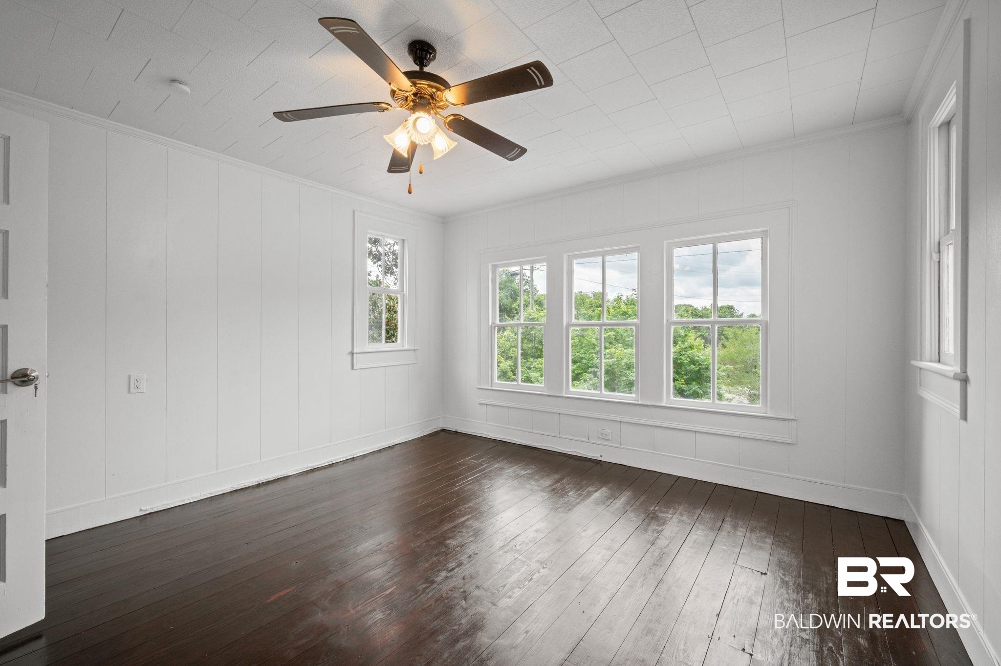 733 Pineville Road Monroeville, AL 36460 - Photo 27 of 68 Spare room with ceiling fan, a decorative wall, baseboards, dark wood-type flooring, and ornamental molding