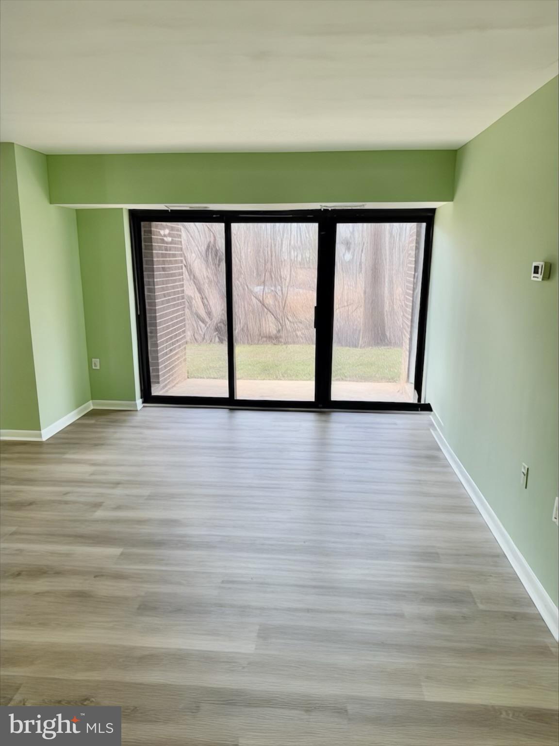 15712 Dorset Road, Unit 198 Laurel, MD 20707 - Photo 11 of 35 a view of an empty room with wooden floor and a window