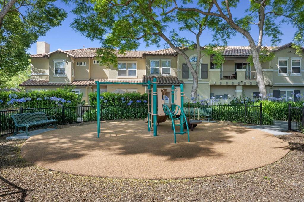6180 Citracado Circle Carlsbad, CA 92009 - Photo 36 of 42 a view of a white house with a fountain plants and a small yard
