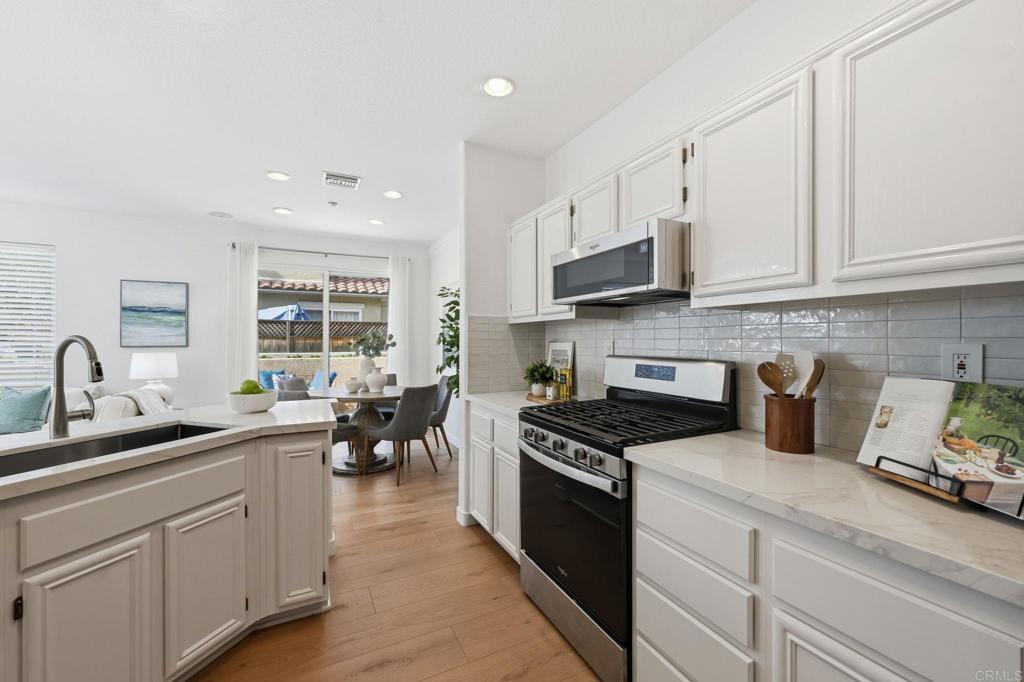 6180 Citracado Circle Carlsbad, CA 92009 - Photo 9 of 42 a kitchen with granite countertop a sink stainless steel appliances and cabinets
