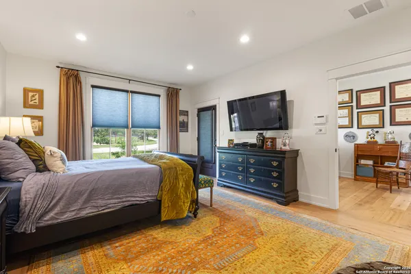 a living room with a bed furniture and a flat screen tv
