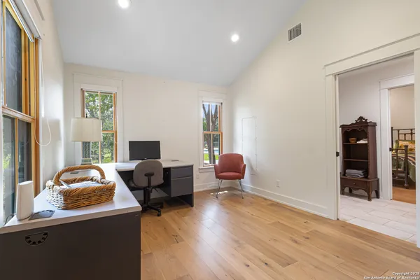 a bedroom with a bed a mirror and a table in it