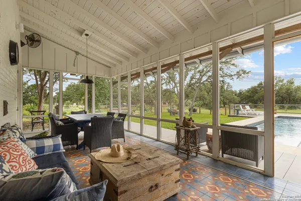 a living room with couch a dining table and a large window