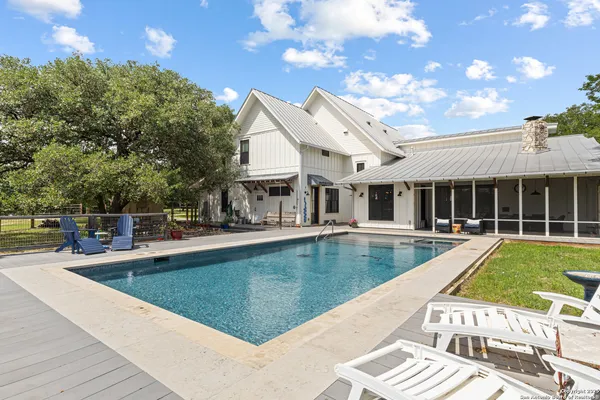 a view of a house with pool and chairs