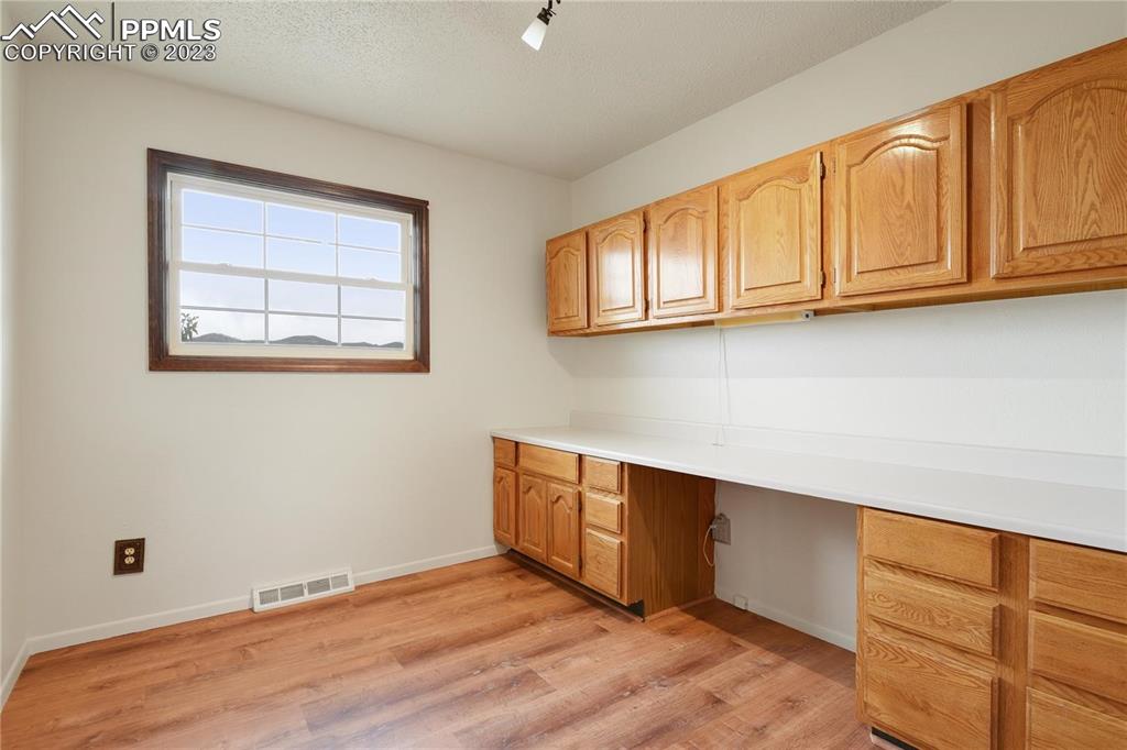 13771 South Hedi Road Sedalia, CO 80135 - Photo 16 of 49 a room with wooden floor and cabinets