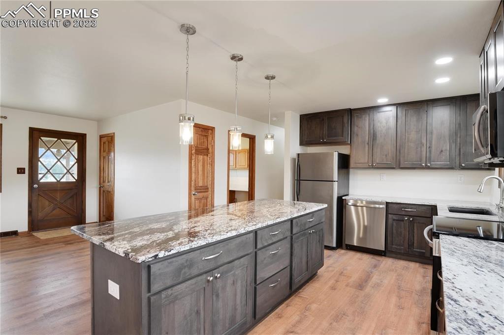 13771 South Hedi Road Sedalia, CO 80135 - Photo 22 of 49 a kitchen with stainless steel appliances granite countertop wooden cabinets a sink dishwasher a stove and a refrigerator