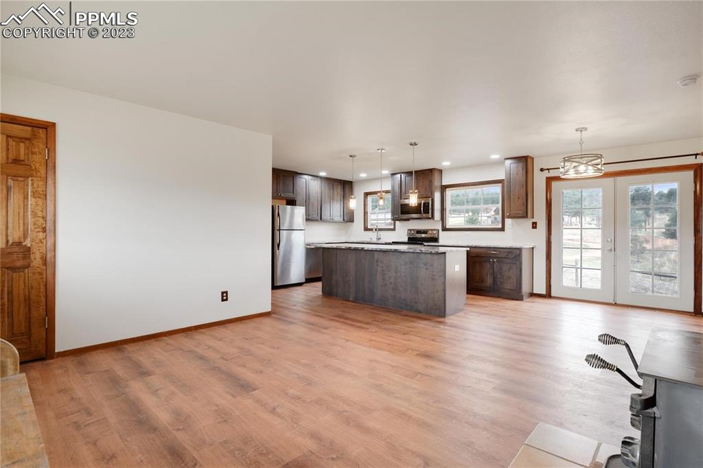 13771 South Hedi Road Sedalia, CO 80135 - Photo 23 of 49 a view of kitchen with stainless steel appliances granite countertop a stove top oven a sink dishwasher and a refrigerator with wooden floor