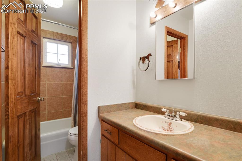 13771 South Hedi Road Sedalia, CO 80135 - Photo 30 of 49 a bathroom with a granite countertop sink a toilet and mirror