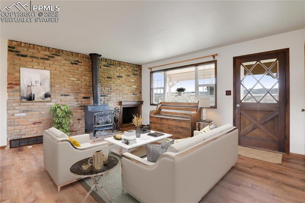 13771 South Hedi Road Sedalia, CO 80135 - Photo 6 of 49 a living room with fireplace furniture and a floor to ceiling window