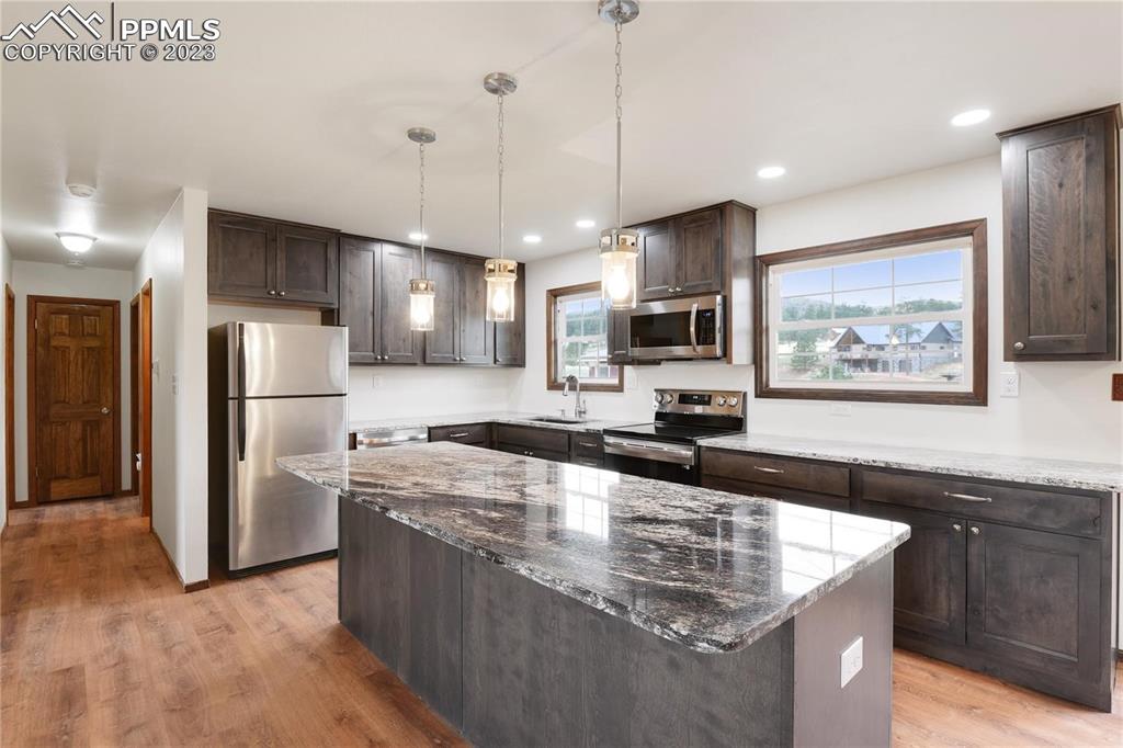 13771 South Hedi Road Sedalia, CO 80135 - Photo 8 of 49 a large kitchen with stainless steel appliances granite countertop a sink a stove and a refrigerator